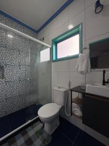 a bathroom with a toilet and a sink and a window at Recanto dos Valles in Búzios +17 photos
