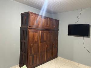 a large wooden cabinet in a room with a television at Apto aconchegante 02 in Aquidauana