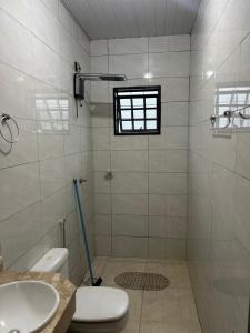 a bathroom with a shower and a toilet and a sink at Apto aconchegante 02 in Aquidauana