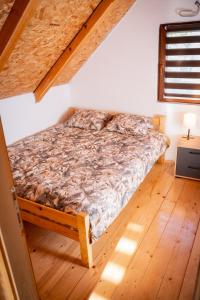 a bed in a room with a wooden floor at Vikendica Vinogradski Mir, Jacuzzi and Vineyard View in Bačinci +24 photos