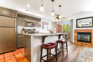 a kitchen with a refrigerator and a counter with stools at Solano Vallejo 3288 in Moab