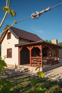 a large white building with a wooden porch at Vikendica Vinogradski Mir, Jacuzzi and Vineyard View in Bačinci