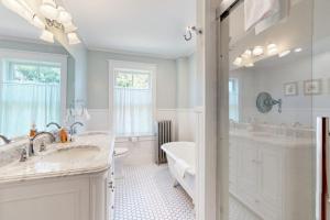 a white bathroom with a tub and a sink at The Worden House in Manchester +43 photos