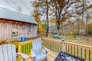 two chairs sitting on a deck next to a barn at Cozy Modern Farmhouse in Wallingford