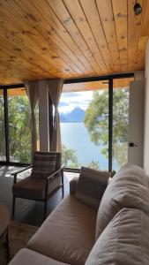 a living room with a couch and a view of the ocean at Jardín de Janaab' in San Antonio Palopó