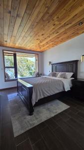 a bedroom with a large bed and a large window at Jardín de Janaab' in San Antonio Palopó