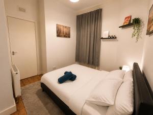 a bedroom with a bed with a blue towel on it at Comfortable 2 Bedroom Flat in Leith in Edinburgh