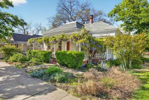 a white house with a garden in front of it at Whimsy on B- 2BR & Studio Near OSF in Ashland
