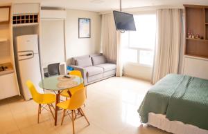 a small room with a bed and a table and chairs at Dna Smart Style in Goiânia