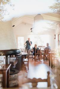 a man standing in a restaurant with people sitting at tables at La Domanda Hostería in Villa Berna