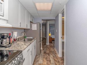 a kitchen with white cabinets and a sink at Boardwalk 1030 in Myrtle Beach