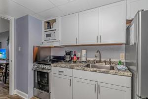 a kitchen with white cabinets and a sink at Boardwalk 1030 in Myrtle Beach +37 photos