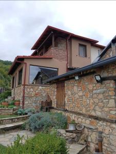 a house with a stone wall and a building at ARTEMIS HOME in Pétra