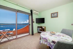 a room with a bed and a balcony with a television at Apartments Djusi in Dramalj