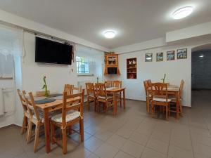 a dining room with tables and chairs and a flat screen tv at Dworek pod świerkami in Jelenia Góra