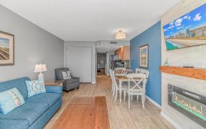 a living room with a blue couch and a fireplace at Atlantica 1055 in Myrtle Beach