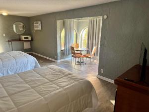 a bedroom with a bed and a table and chairs at Ocean 12 Beach Hotel in Myrtle Beach