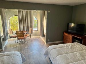 a bedroom with a table and chairs and a television at Ocean 12 Beach Hotel in Myrtle Beach