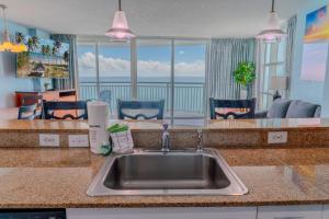 a kitchen with a sink and a view of the ocean at Sandy Beach 1612 in Myrtle Beach