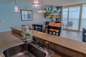 a kitchen with a sink and a living room at Sandy Beach 1612 in Myrtle Beach