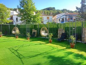 a garden with a fence and chairs and plants at Villa Cultural MONTELUCÍA in Montecorto