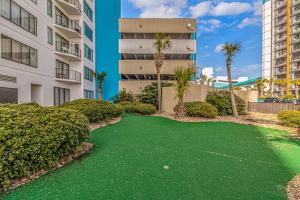 a golf course with palm trees and buildings at The Palace 505 in Myrtle Beach
