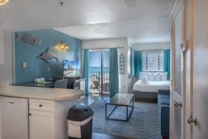 a hotel room with a bedroom with a bed and a room at The Palace 505 in Myrtle Beach