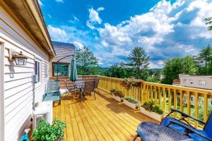 a wooden deck with chairs and an umbrella at Mountainside Resort F401 in Stowe