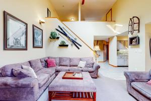 a living room with two couches and a table at Trail Creek 33 in Killington
