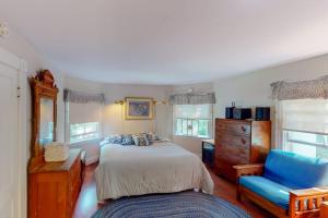 a bedroom with a bed and a blue chair at Garden Island's Maple in Charlotte