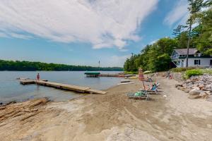 a beach with chairs and a dock and a house at Garden Island's Maple in Charlotte