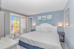 a bedroom with a large white bed and a window at Boardwalk 439 & 440 in Myrtle Beach
