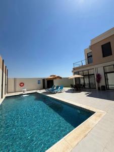 a swimming pool in front of a building at Royal Pearl Villa 1 in Sowayma