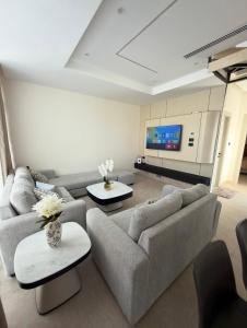 a living room with couches and a flat screen tv at Royal Pearl Villa 1 in Sowayma