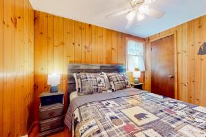 a bedroom with a bed with wooden walls and a ceiling at Potter's Place in Jamaica