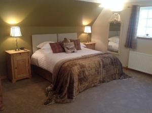 a bedroom with a large bed and two lamps at Lochview Guesthouse in Contin