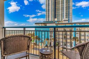 a balcony with two chairs and a table and a building at Oceanview Studio at Boardwalk Resort 440 in Myrtle Beach