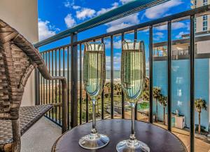a table with two wine glasses on a balcony at Oceanview Studio at Boardwalk Resort 440 in Myrtle Beach +22 photos