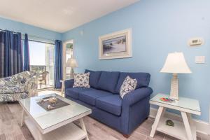 a blue living room with a blue couch and a table at The Palace 1513 in Myrtle Beach
