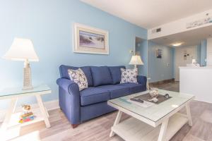 a living room with a blue couch and a table at The Palace 1513 in Myrtle Beach