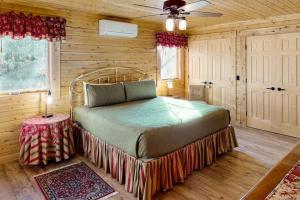 a bedroom with a bed in a wooden room at Blackbear Log Cabin in Morrisville
