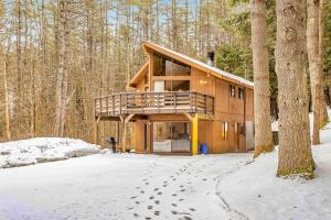 a house in the woods with footprints in the snow at Dwight Road Getaway in Quechee