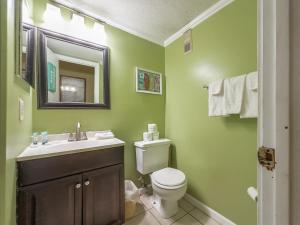 a bathroom with a toilet and a sink and a mirror at A Place at the Beach 406 in Myrtle Beach