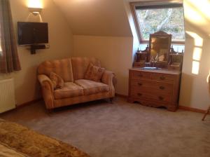 a living room with a chair and a dresser at Lochview Guesthouse in Contin