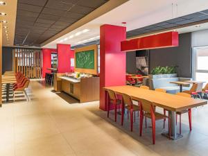 a dining room with a wooden table and chairs at ibis Chapeco in Chapecó