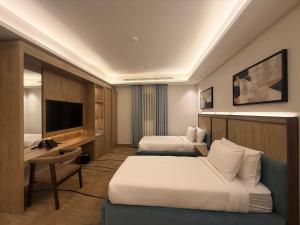 a hotel room with two beds and a television at فندق أثير بارك in Jazan