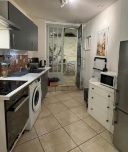 a kitchen with a washer and dryer in it at Bright Nîmes Center Flat with Terrace in Nîmes