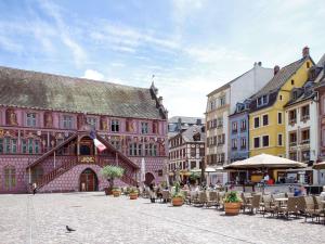 a city street with tables and chairs and buildings at Ibis Styles Mulhouse Centre Gare in Mulhouse