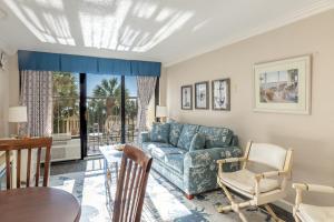 a living room with a blue couch and a table at Relaxing Oceanfront Condo - Holiday Pavilion 211 in Myrtle Beach