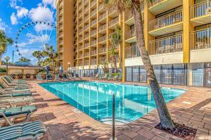 a swimming pool at a resort with a wheel at Relaxing Oceanfront Condo - Holiday Pavilion 211 in Myrtle Beach